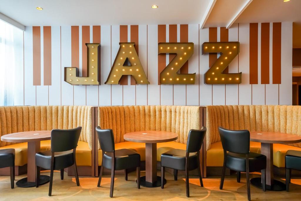 a restaurant with tables and chairs and the word kale at Kyriad - Créteil - Bonneuil-sur-Marne in Bonneuil-sur-Marne