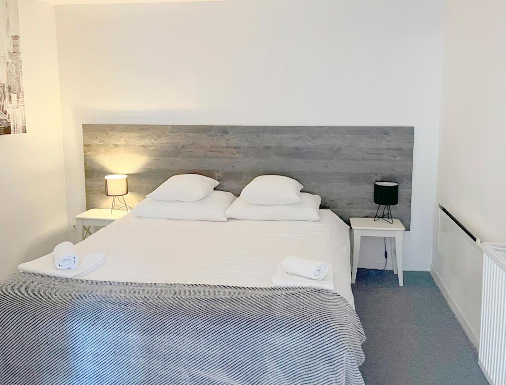 sypialnia z dużym białym łóżkiem z dwoma stołami w obiekcie Bed & Bike Zagreb studio apartment w Zagrzebiu