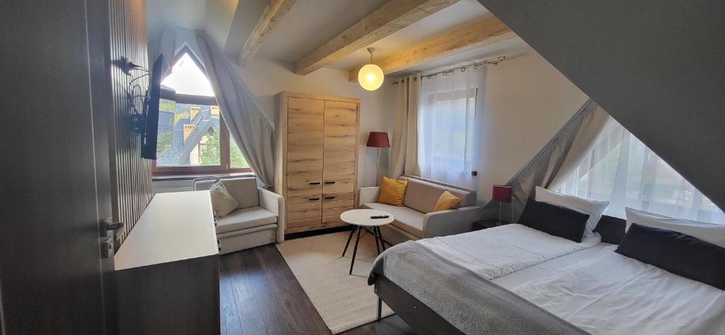 um pequeno quarto com uma cama e uma janela em Walkowy Dwor em Zakopane