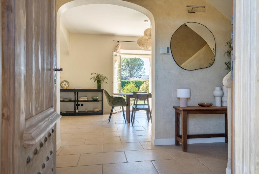 a hallway with a table and a mirror on the wall at La Bastide Des As in Gordes