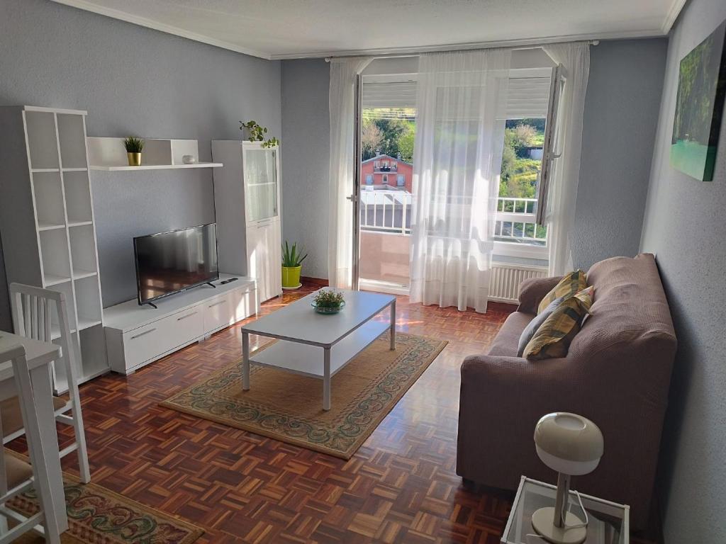 sala de estar con sofá y mesa en Los Tilos, en Ramales de la Victoria