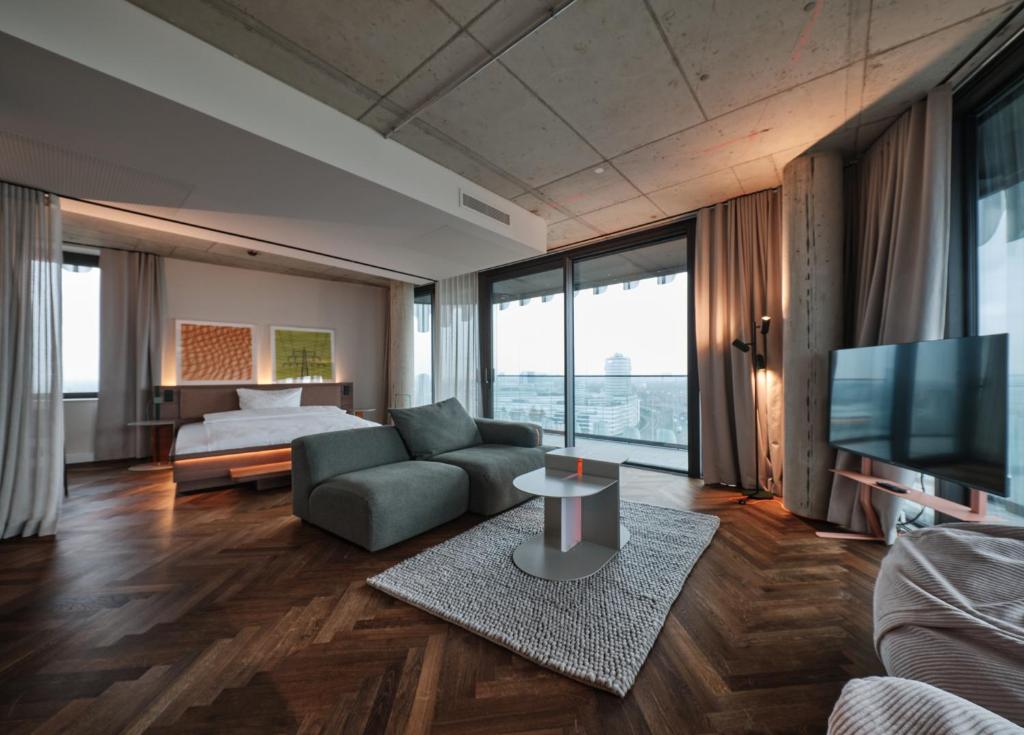 a living room with a couch and a bed and a television at The Zipper Hotel und Apartments in Düsseldorf