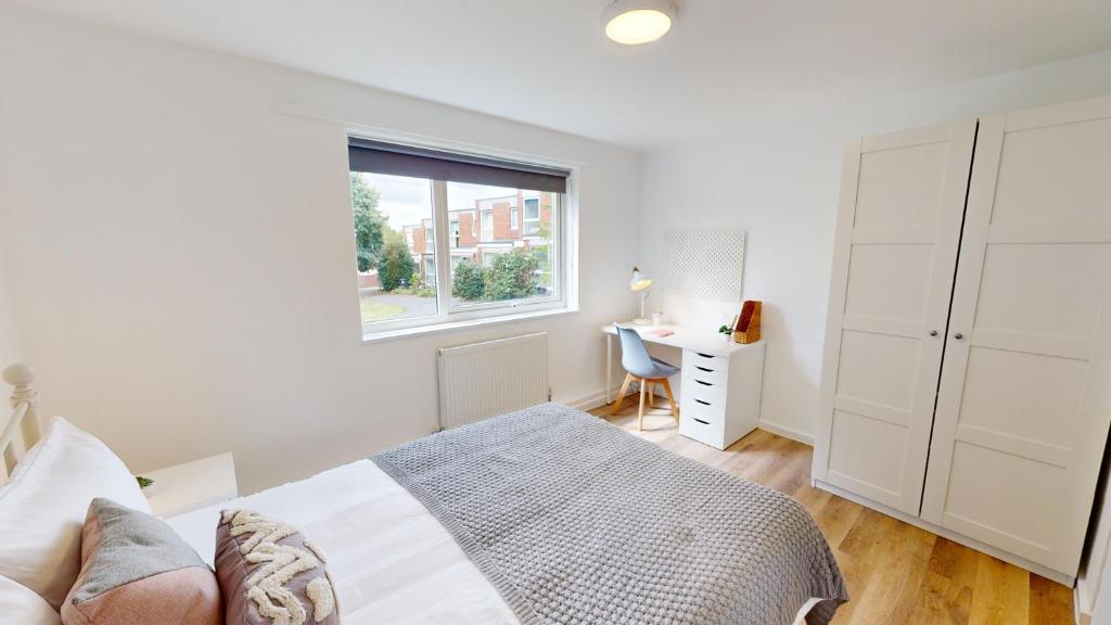 1 dormitorio con cama, escritorio y ventana en Inviting Apt near the Valley Park en Exeter