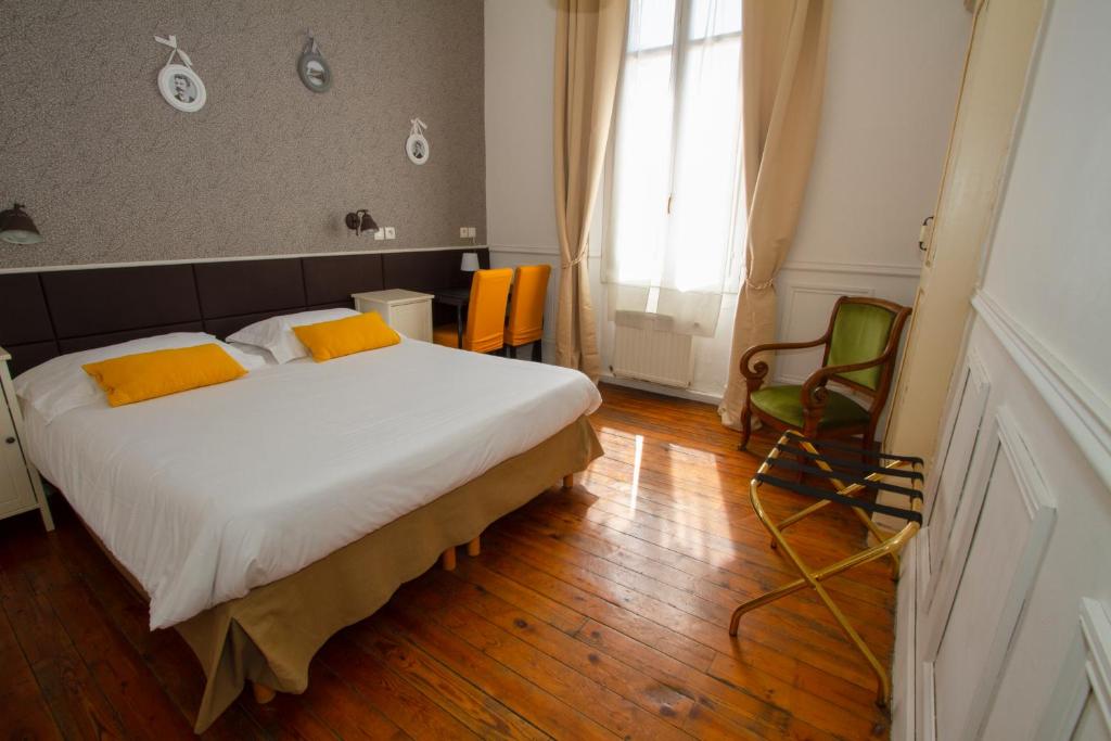 um quarto com uma cama e uma cadeira em Hotel Chalet De L'isere em Cannes