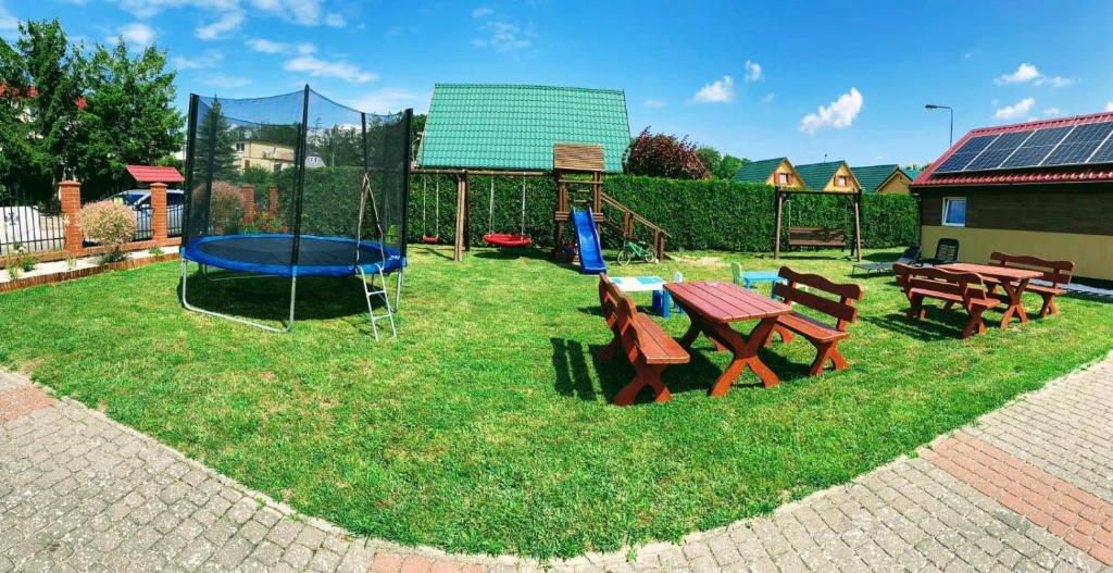 einen Spielplatz mit einem Picknicktisch und einem Trampolin in der Unterkunft Domki u Marcina in Sarbinowo