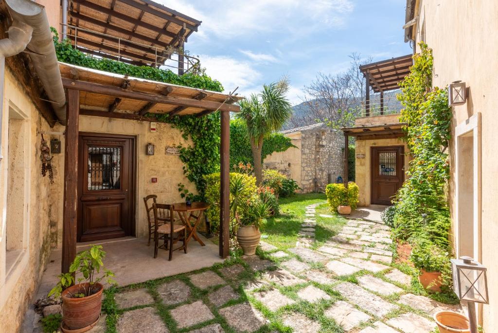 a patio with a table and chairs in a yard at Kalimera Archanes Village in Archanes