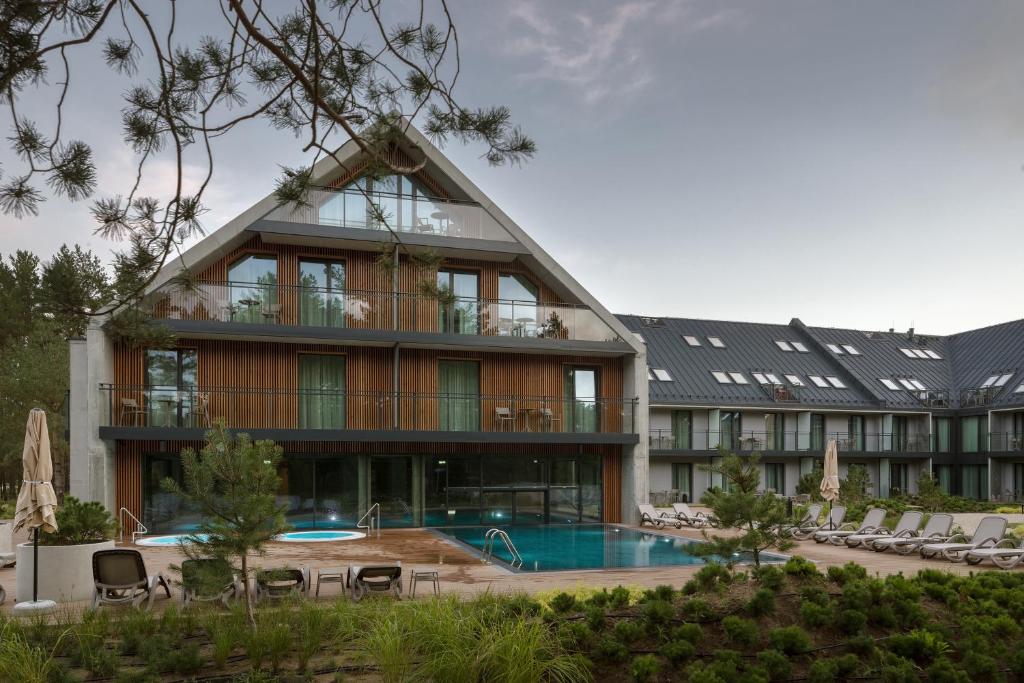 ein großes Gebäude mit einem Pool und einem Resort in der Unterkunft Hotel Saltic Resort & Spa Łeba in Łeba