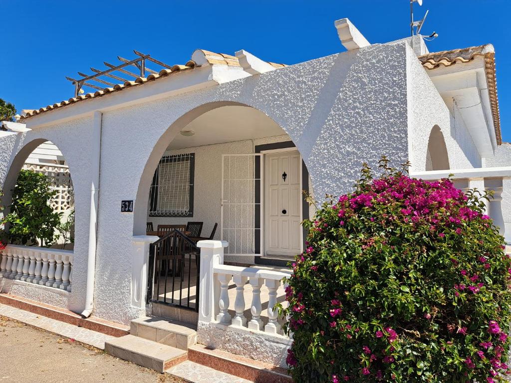 Biały dom z białym płotem i kwiatami w obiekcie Pretty villa with private pool w mieście Los Alcázares