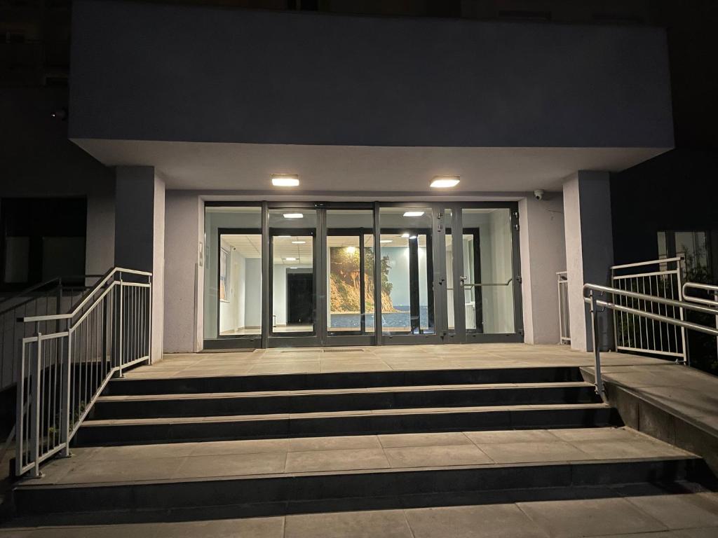 a building with glass doors and stairs in front at Gdynia Riviera Hills in Gdynia