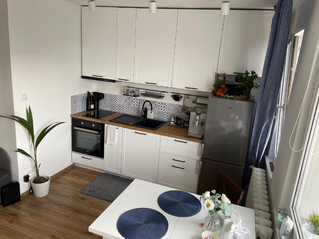 a small kitchen with white cabinets and a table at Gdynia Riviera Hills in Gdynia