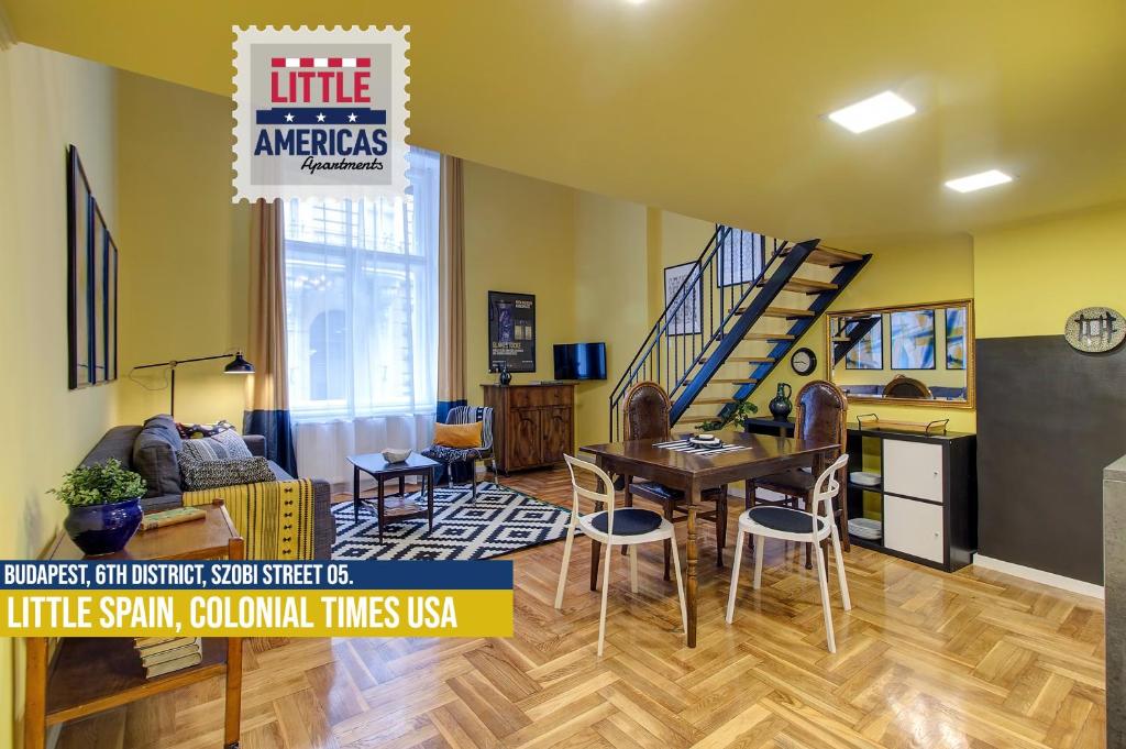 a living room with a table and chairs and a staircase at Little Americas Colonial Times Apts in Budapest