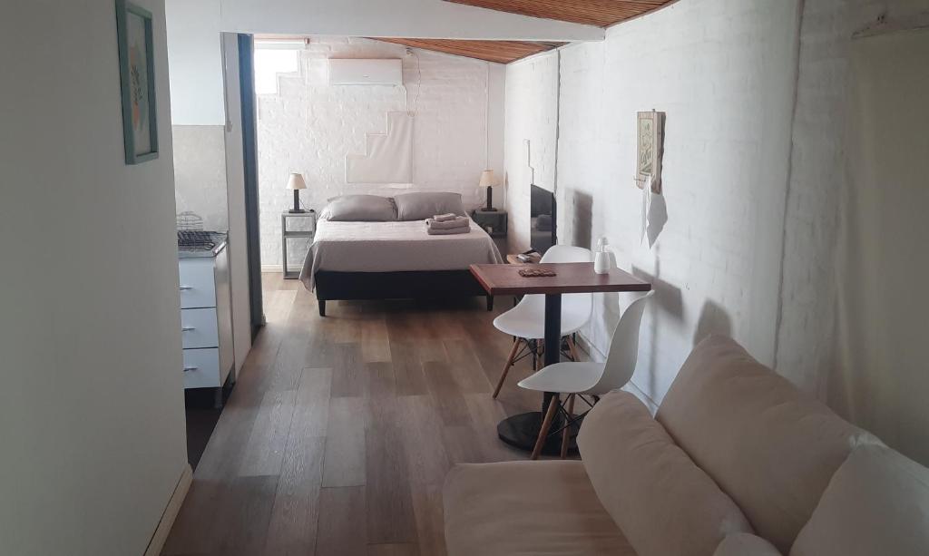 Confortable apartamento-monoambiente en Mercedes في مرسيدس: غرفة معيشة مع سرير وأريكة وطاولة