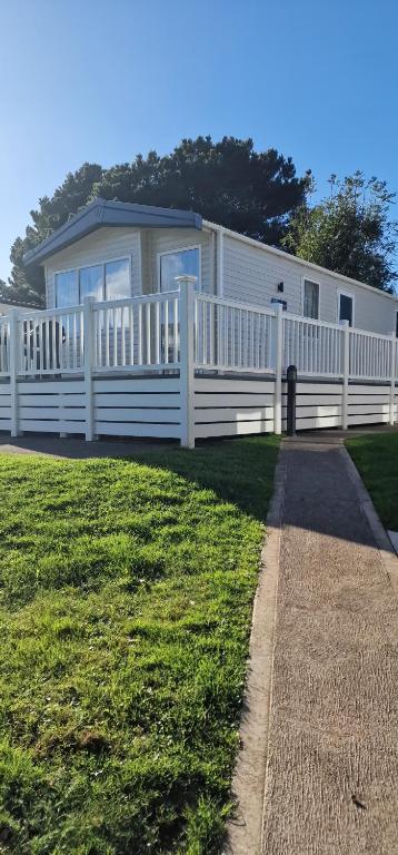 a white mobile home with a white fence at Holibobs in Paignton