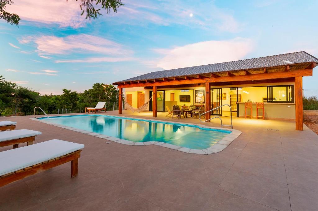 a patio with a swimming pool and a house at Anacã Ecolounge in Bonito