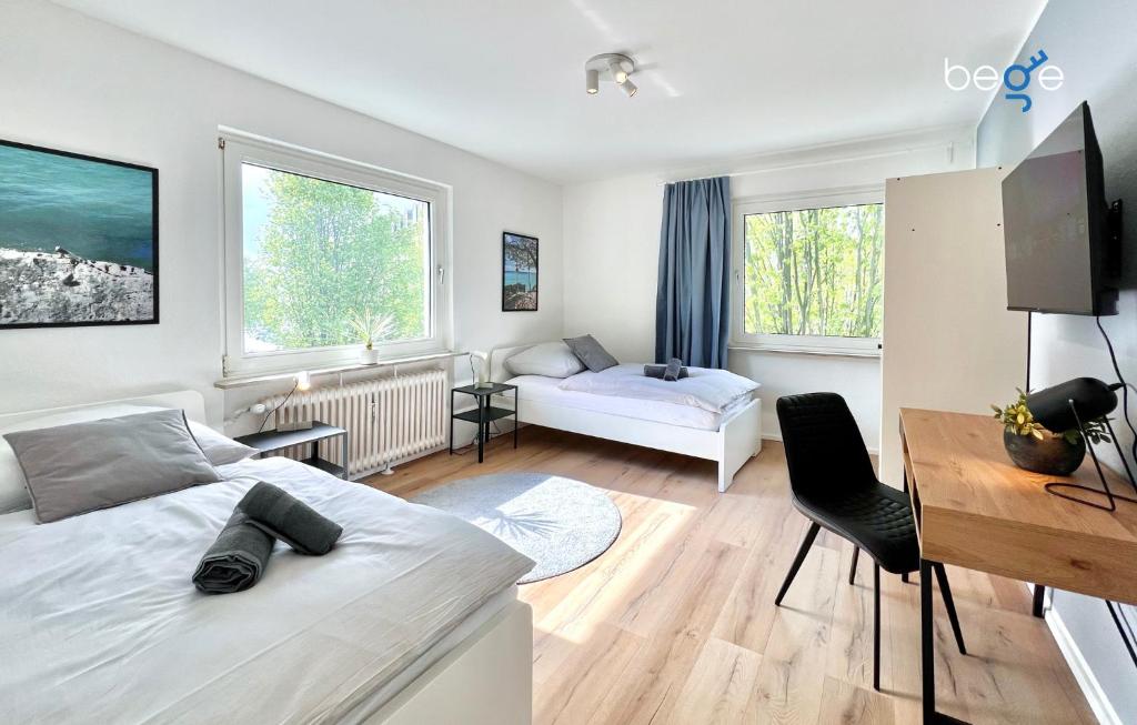 een slaapkamer met een bed, een bureau en een bank bij BEGE APARTMENTS Business Residence in Hagen