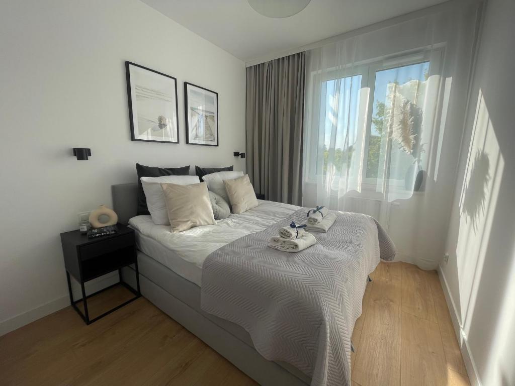a white bedroom with a large bed with a window at Eden Puck in Puck