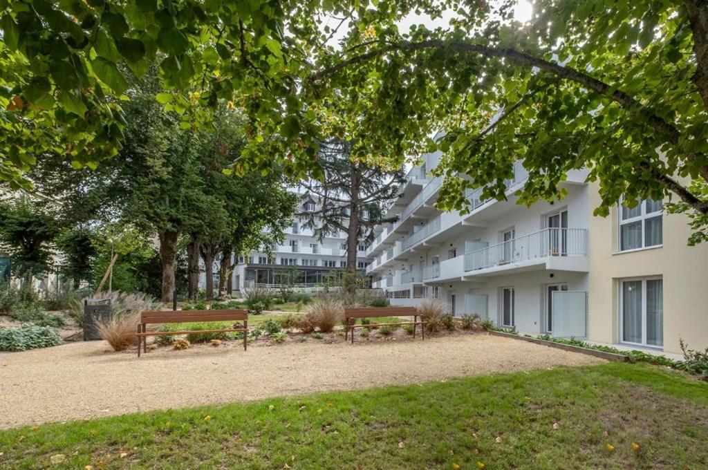 シャテルローにあるRésidence de Châtellerautの建物前の公園ベンチ2つ