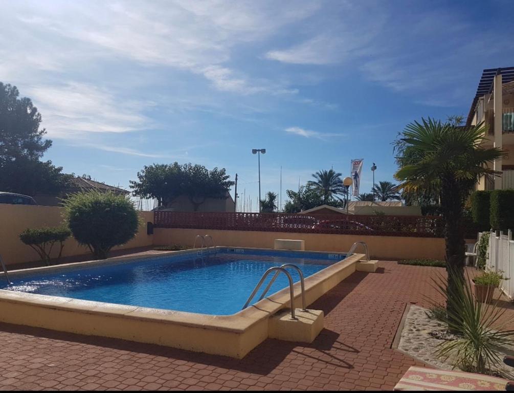 une grande piscine dans une cour en briques avec dans l'établissement Appartement Saint Cyprien Port, à Saint-Cyprien