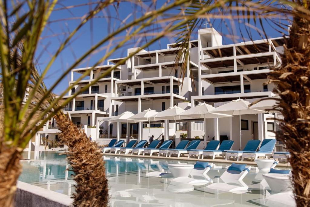 un gran edificio blanco con sillas y piscina en Residence 201 New Oceanfront Resort Style Amenities Cerritos, en El Pescadero