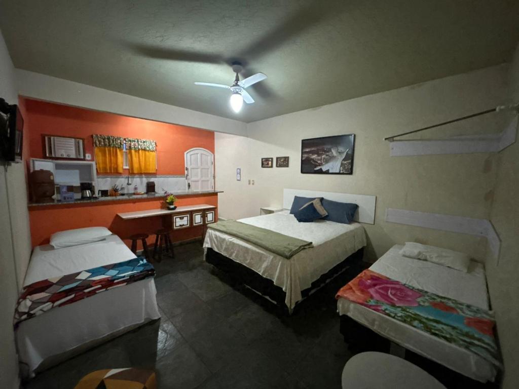 um quarto com 2 camas, uma secretária e uma cozinha em Flats vila bela Búzios em Búzios