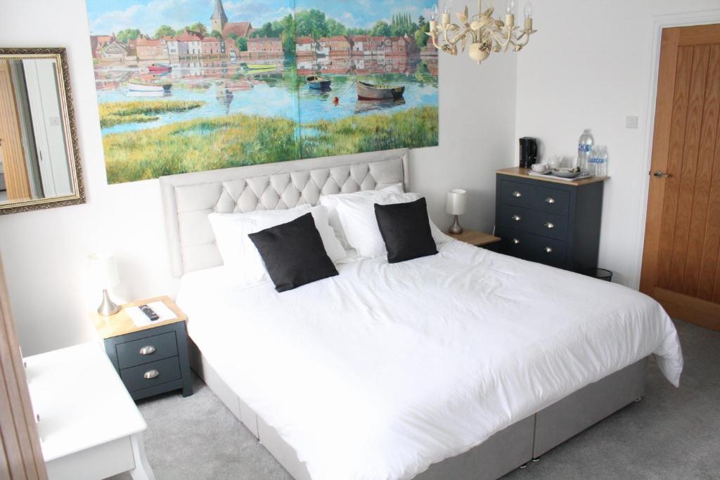 um quarto com uma cama branca e um quadro na parede em Westleigh House em Fishbourne