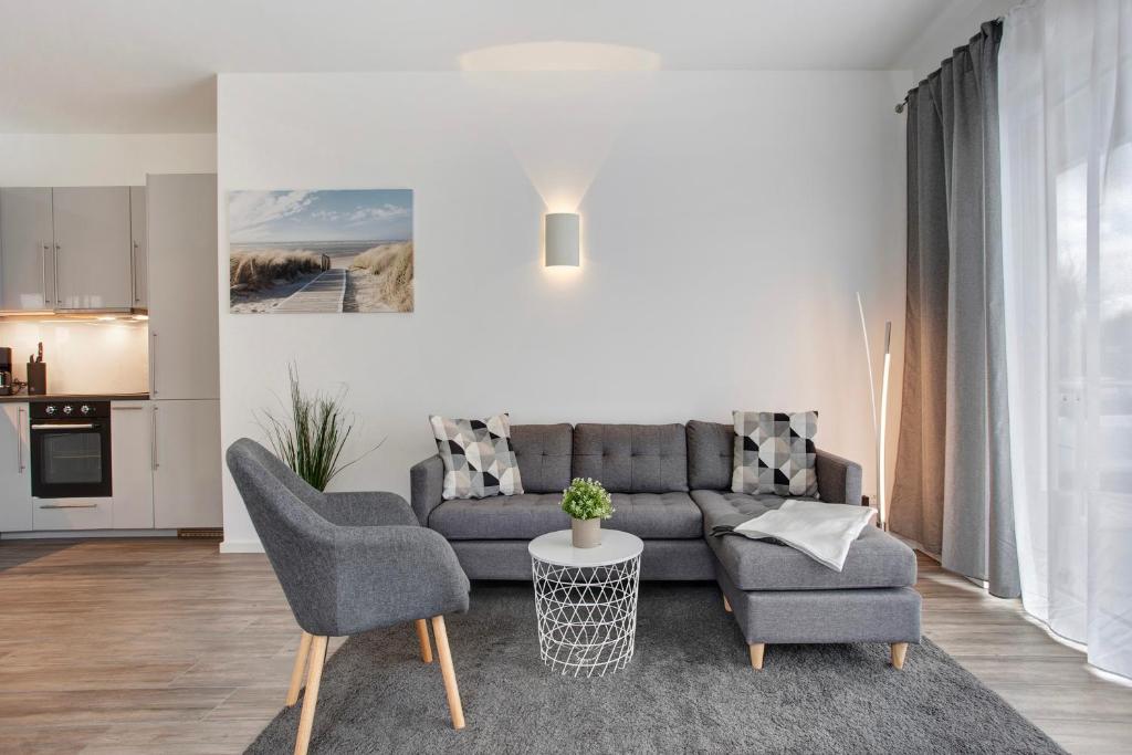 a living room with a couch and two chairs and a table at Wohnung Abendrot in Heringsdorf