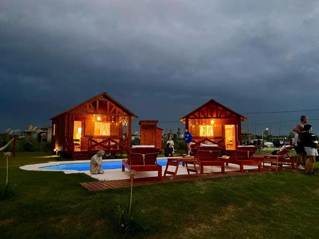 a couple of huts with tables and chairs in the grass at SanDo Uribe Cabañas Exclusivas solo adultos in Uribelarrea