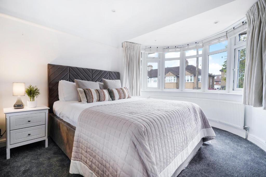 a white bedroom with a bed and a window at Hububb Luxury Eastcote in Eastcote