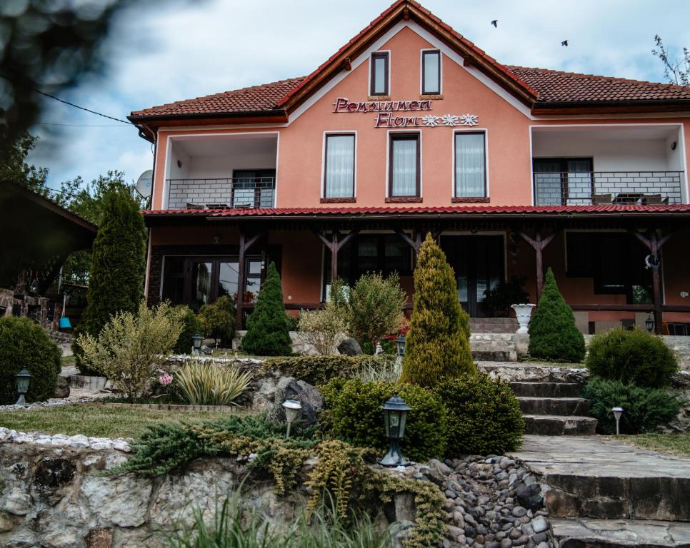 una casa con un jardín delante de ella en Complex Agroturistic Flori, en Vaţa de Jos