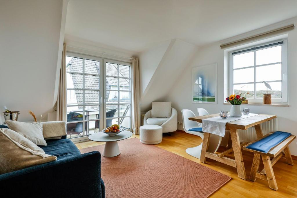 a living room with a couch and a table at Ferienwohnung-Sandblume-mit-Meerblick in Hörnum