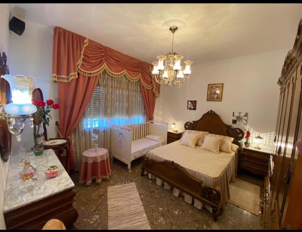 1 dormitorio con cama y lámpara de araña en Casa Chalet Venta Ruizo, en Lorca