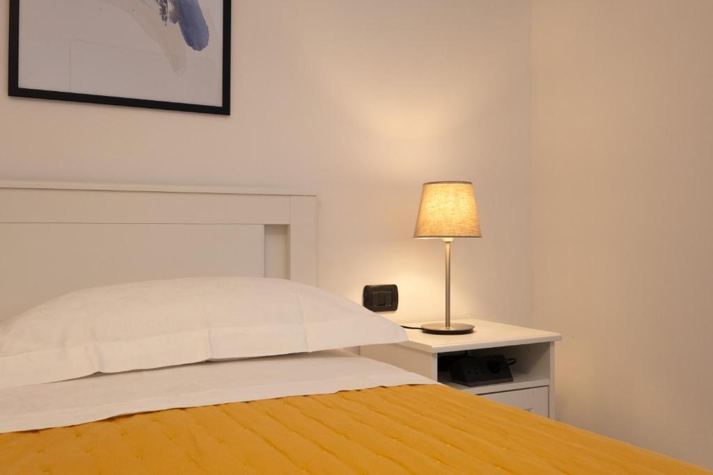 een slaapkamer met een bed en een lamp op een bureau bij Bilocale a Lainate LainHouse in Lainate