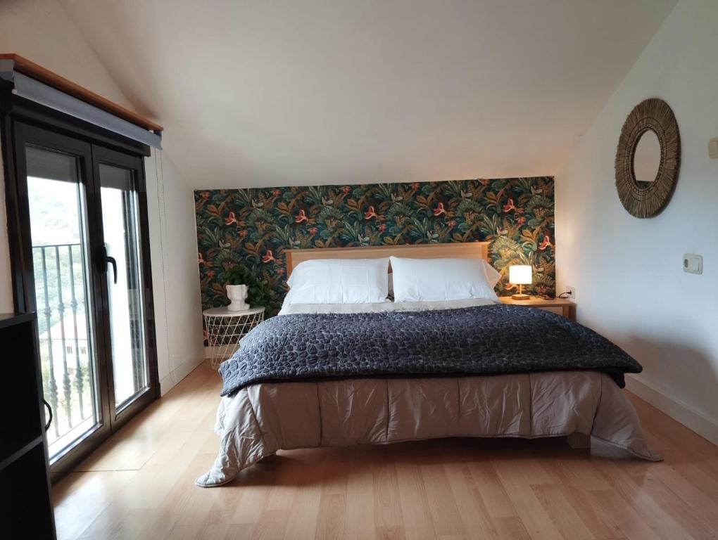 a bedroom with a large bed with a large window at Isla in Oiartzun