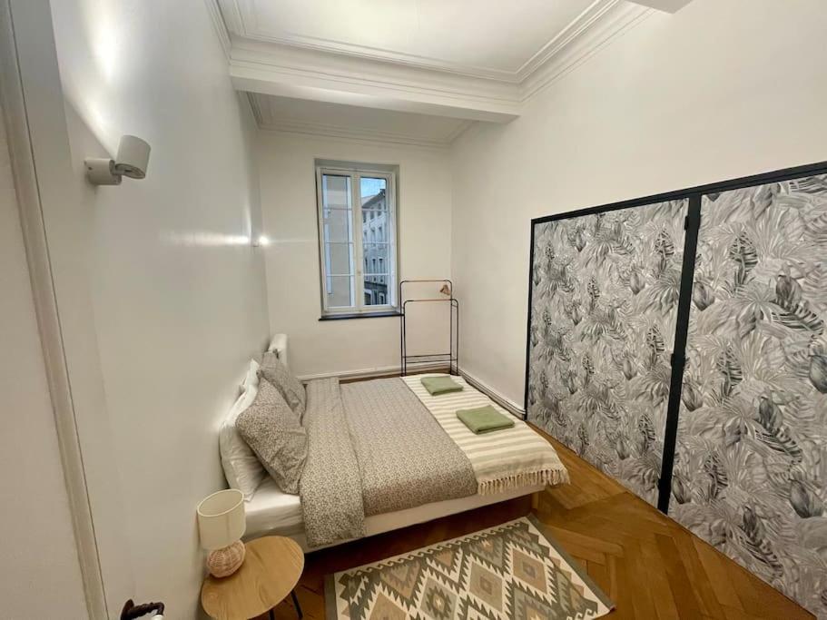 Kleines Zimmer mit einem Bett und einem Fenster in der Unterkunft Grand appartement de charme proche Cité in Carcassonne