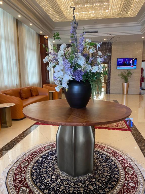 a vase of flowers on a table in a lobby at 8&9Hotel in Pointe-Noire