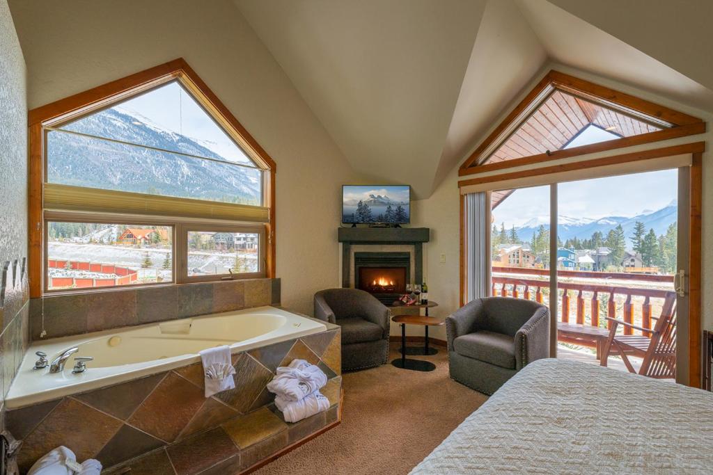 a bedroom with a bath tub and a fireplace at A Bear and Bison Country Inn in Canmore