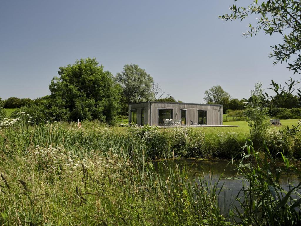 ein kleinolithicolithicolithicolithicolithicolithicolithicolithicolithiothicolithicolitithicolithicolithic house in einem Feld in der Unterkunft Nunney Lodge in Beckington