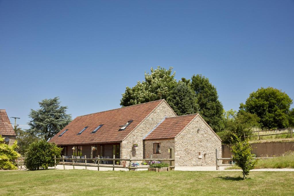 a large brick building with a gambrel roof at Selwood Cottage in Beckington