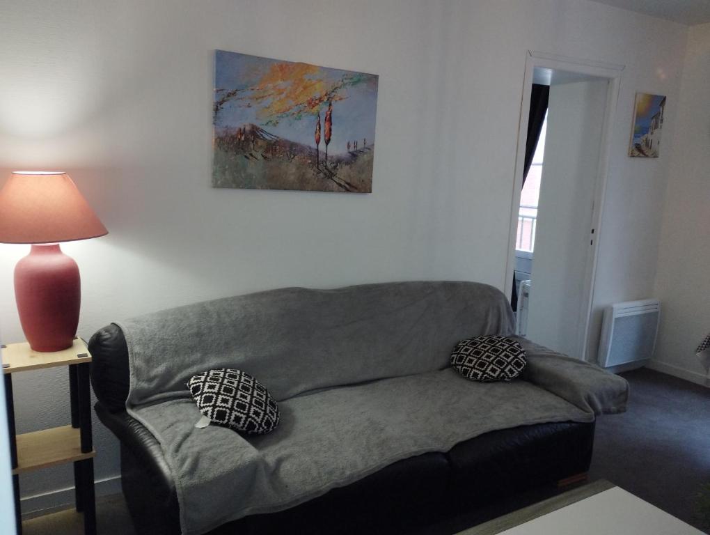 un salon avec un canapé et un tableau au mur dans l'établissement La Plaisance, à Dieppe