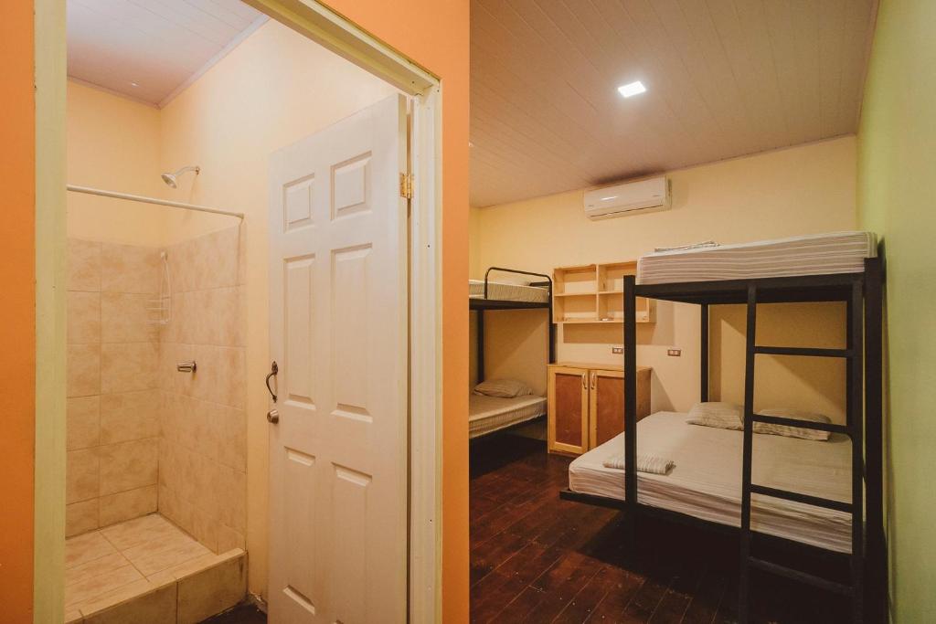 a room with two bunk beds and a shower at Habitat Surf Glamp in Santa Teresa Beach