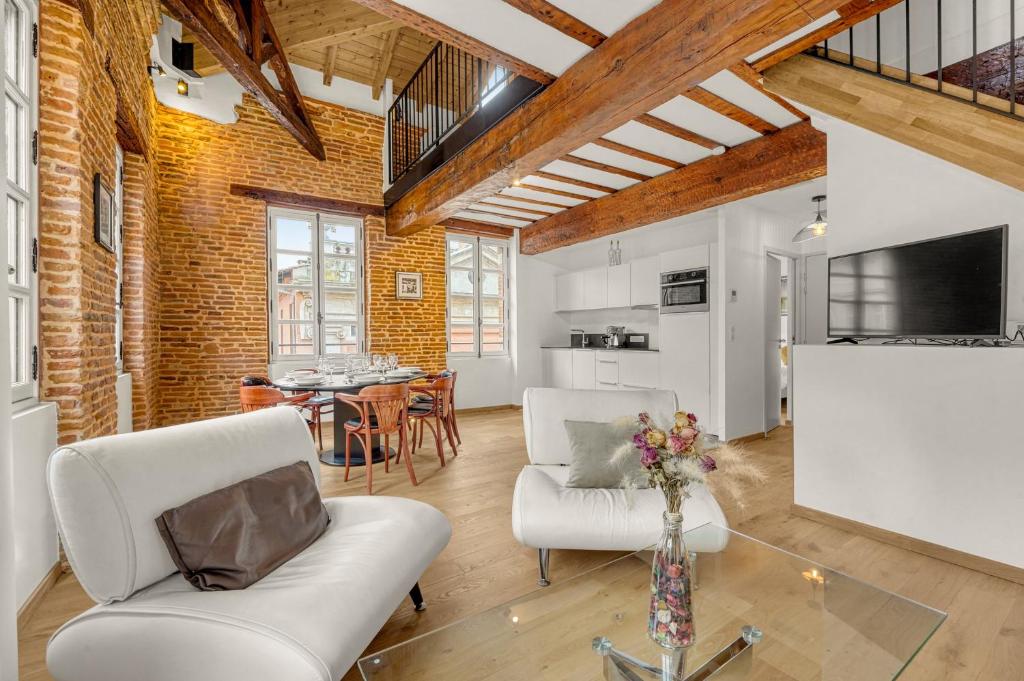 un salon avec deux chaises blanches et une table dans l'établissement Monsieur Henri - Grand appt en plein centre ville, à Toulouse