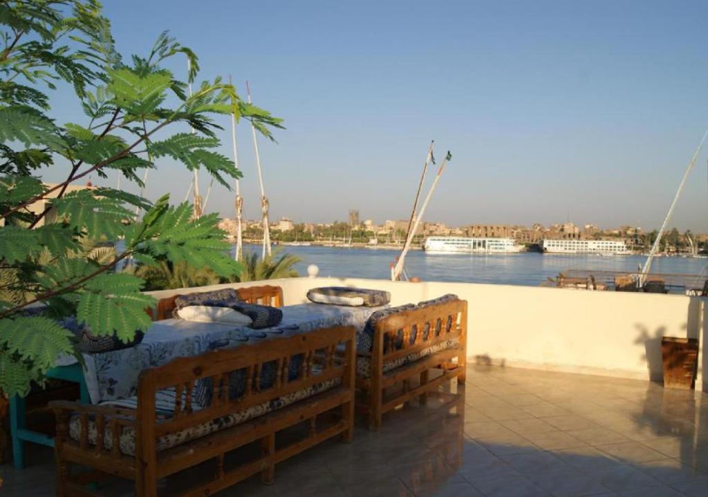 una mesa en un patio junto a un cuerpo de agua en Gîte Hôtel Gezira Louxor, en Luxor