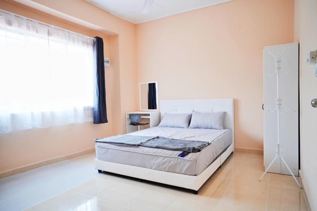 1 dormitorio con cama blanca y ventana en Peach Homestay Tasik Puteri, en Rawang