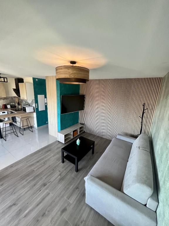 un salon avec un canapé et une table dans l'établissement Studio élégant avec accès à la piscine, à Nice