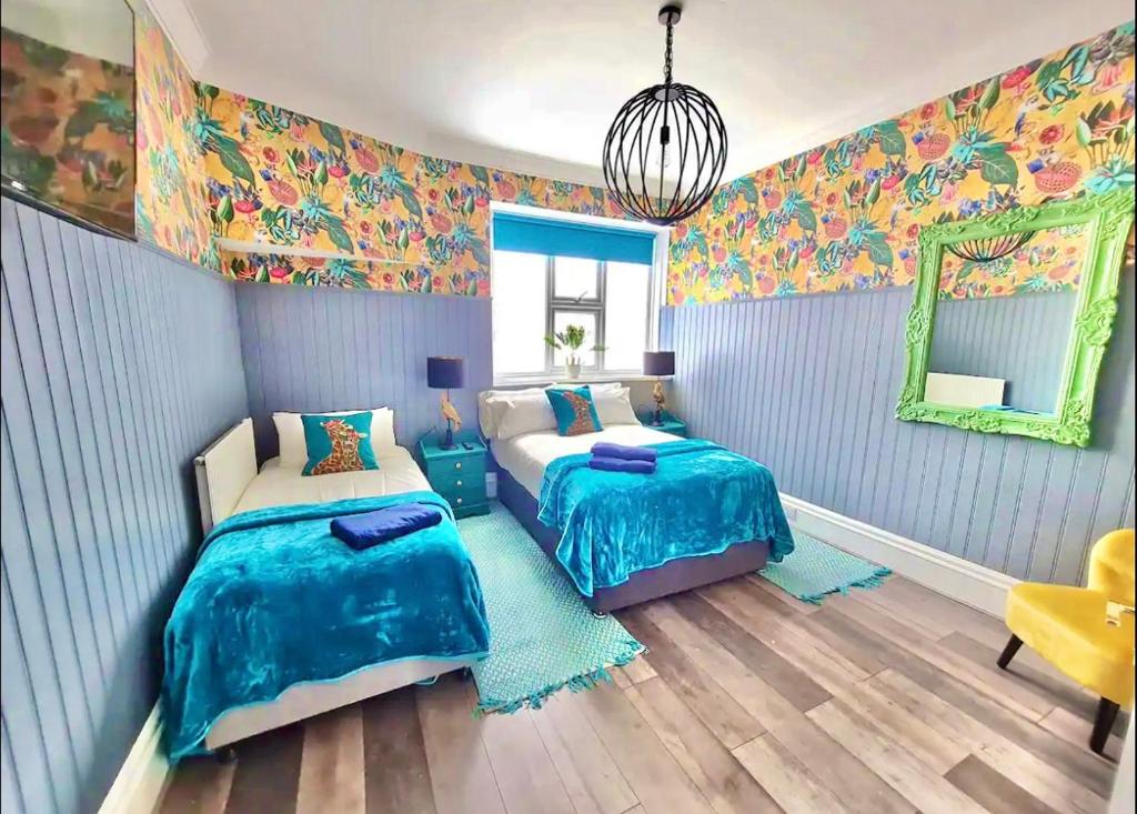 1 Schlafzimmer mit 2 Betten und einem Spiegel in der Unterkunft Yellow Lemur Apartment - Lemur Lodge - Short Stroll to the Beach - Free Wifi in Bournemouth