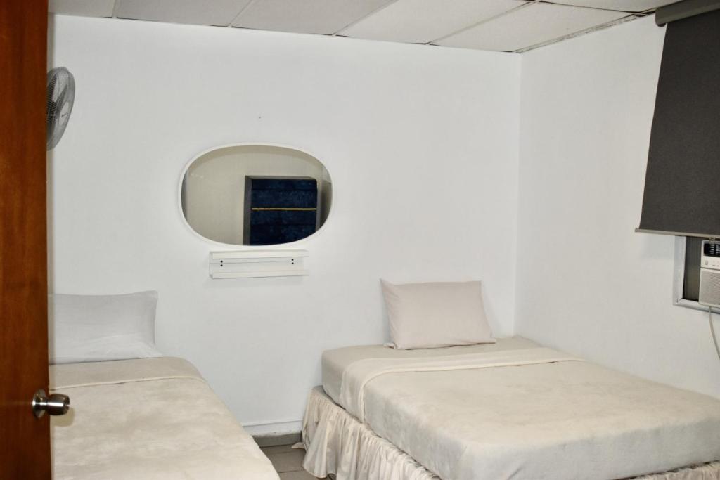 Zimmer mit 2 Betten und einem Spiegel in der Unterkunft Group Unit Great Location in San Juan