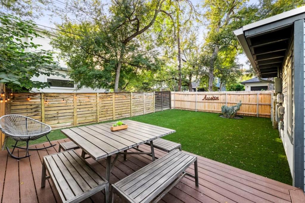 a backyard with a picnic table and a fence at Mid-century home in Zilker with a backyard in Austin