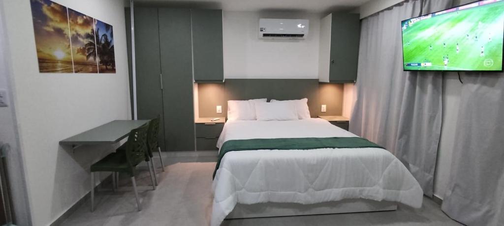 ein Schlafzimmer mit einem Bett und einem Flachbildfernseher in der Unterkunft Flat 304 Porto Prime com Rooftop e Piscina in Porto De Galinhas
