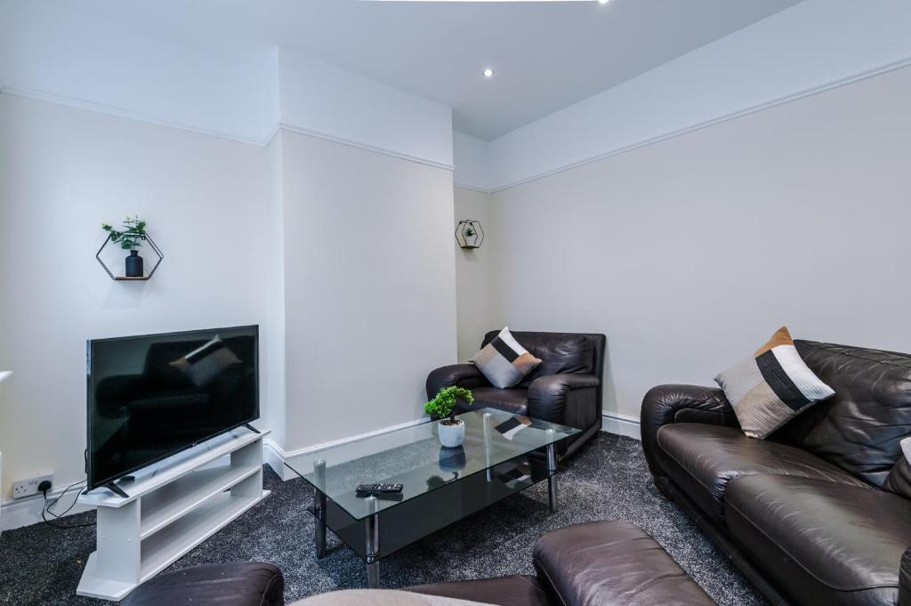a living room with two leather couches and a tv at Modern 3-Bedroom Apartment - Sleeps 5 in Liverpool