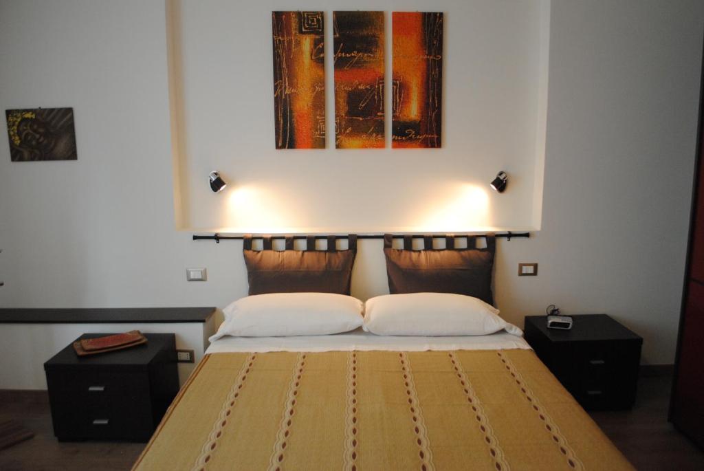 1 dormitorio con 1 cama con 2 almohadas y una pintura en Casa Gordigiani - bilocali con parcheggio, en Florencia
